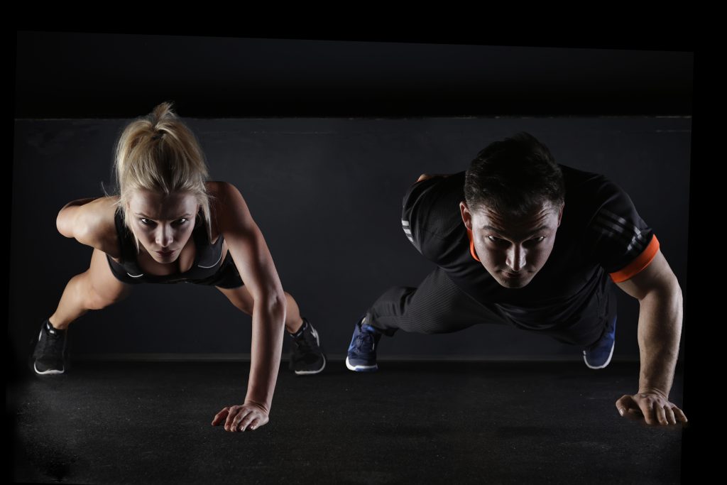 Man and woman doing push-ups together for triceps workouts at home