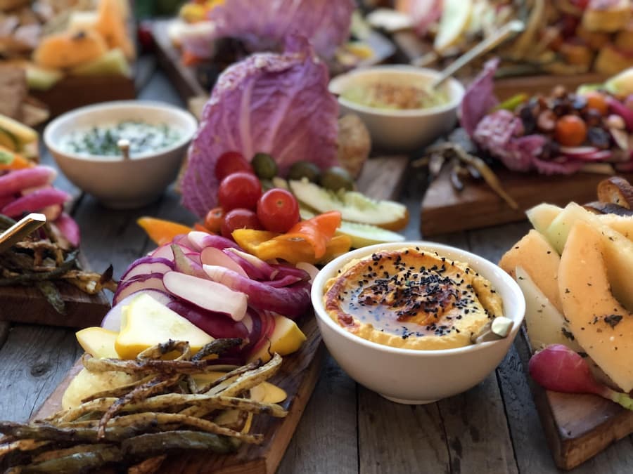 Colorful vegan snack board with fruits, nuts, vegetables and dips as heart healthy snacks