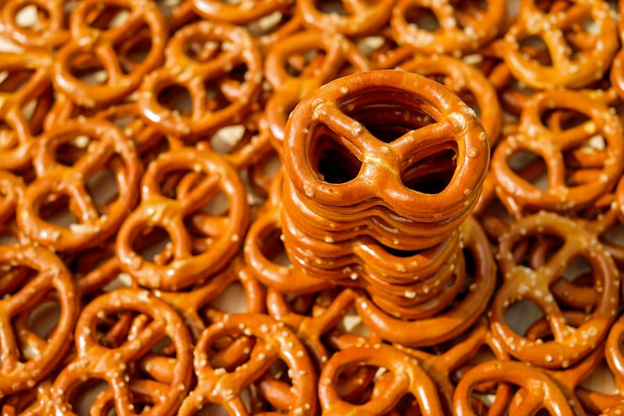 Stack of salted hard pretzels on a pile of crunchy pretzels