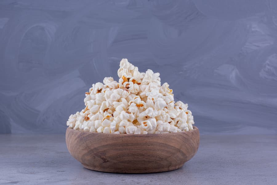 Air-popped popcorn in a wooden bowl, a whole-grain healthy school snack for older kids