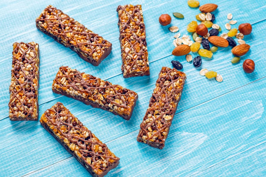 Protein snack bars with mixed nuts and dried fruit on a blue table