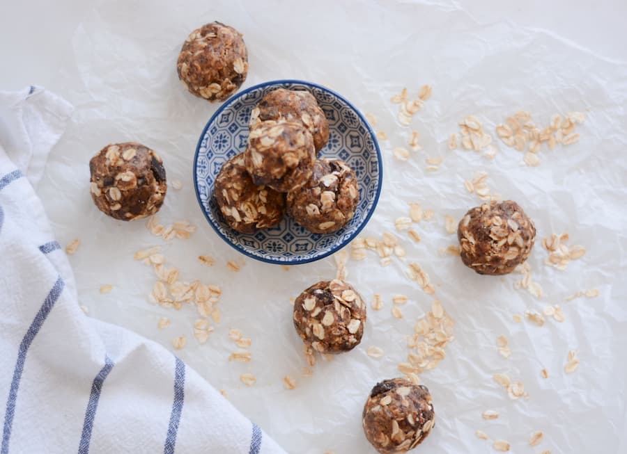 Oatmeal energy bites in a small bowl with rolled oats, a healthy school snack