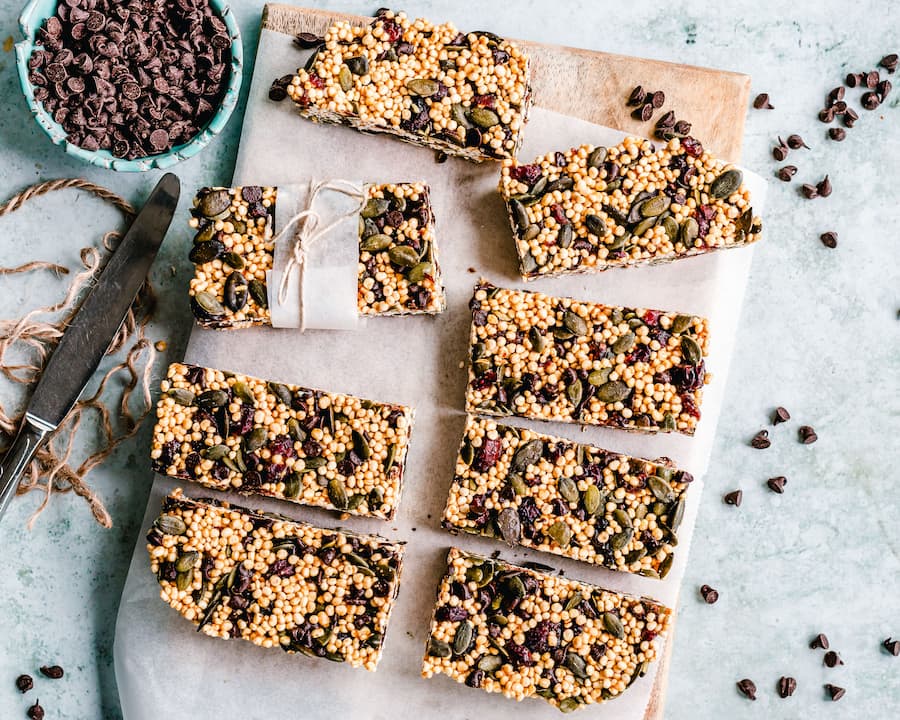 homemade seed snack bars with pumpkin seeds and cranberries cut into bars on parchment paper