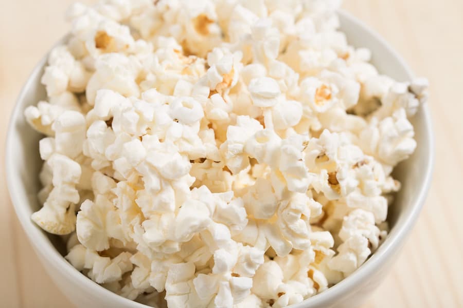 A white bowl of plain air-popped popcorn