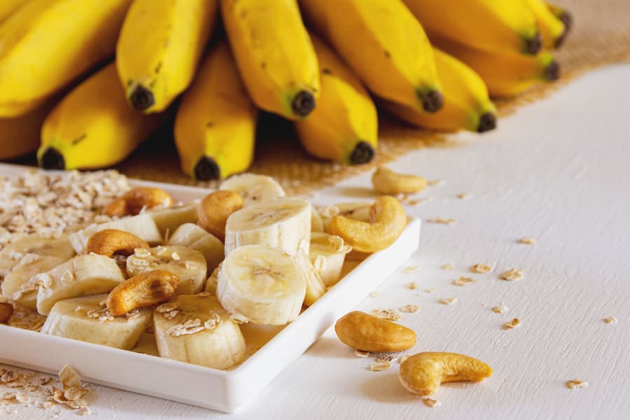 ripe bananas, sliced banana, oats and cashews, ingredients for banana oat snack bars