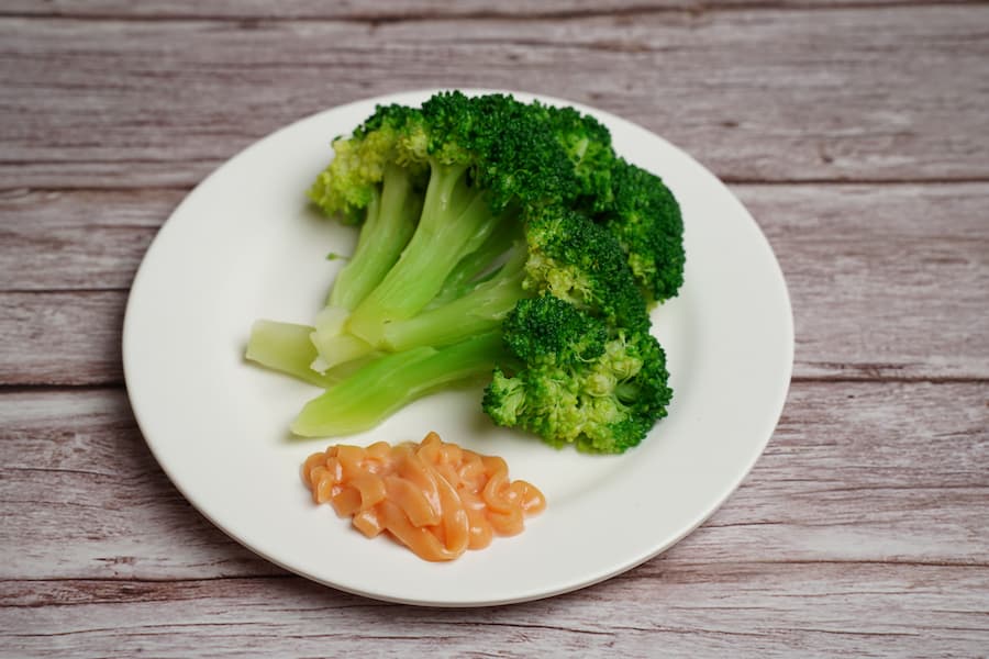 Steamed broccoli florets served on a white plate