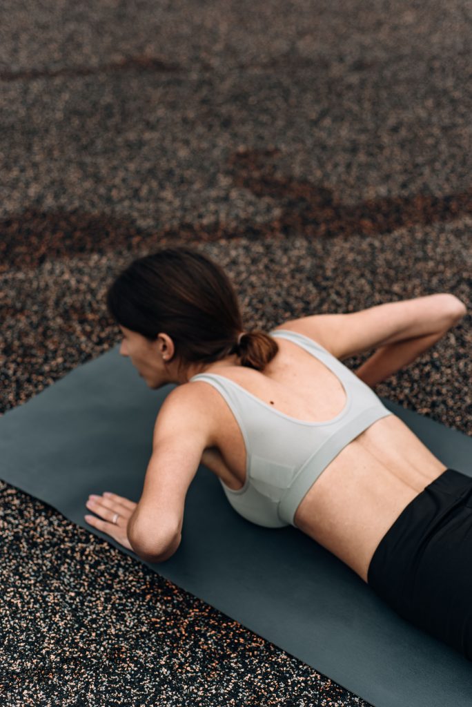 Woman lying on a mat doing a back strengthening exercise