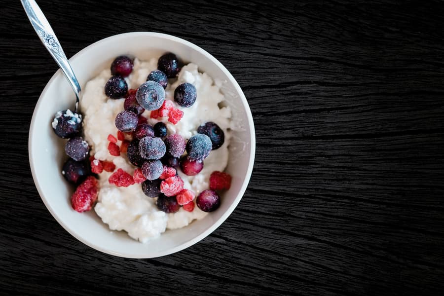 Bowl of cottage cheese topped with blueberries and red berries