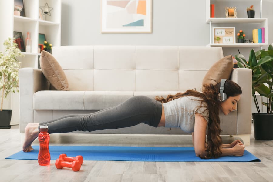 Woman doing a plank on an exercise mat in a home workout