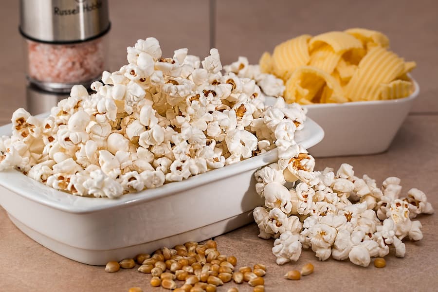 bowl of homemade air-popped popcorn with scattered popcorn and corn kernels